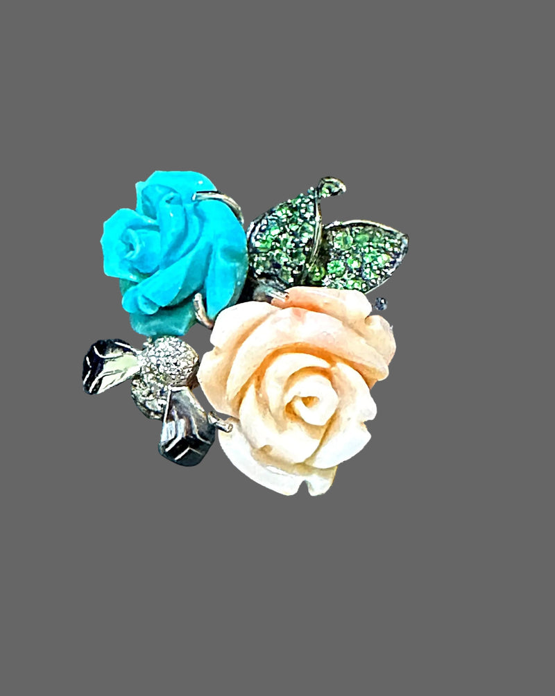 Ring with turquoise and peach roses and green gemstones on a black velvet background